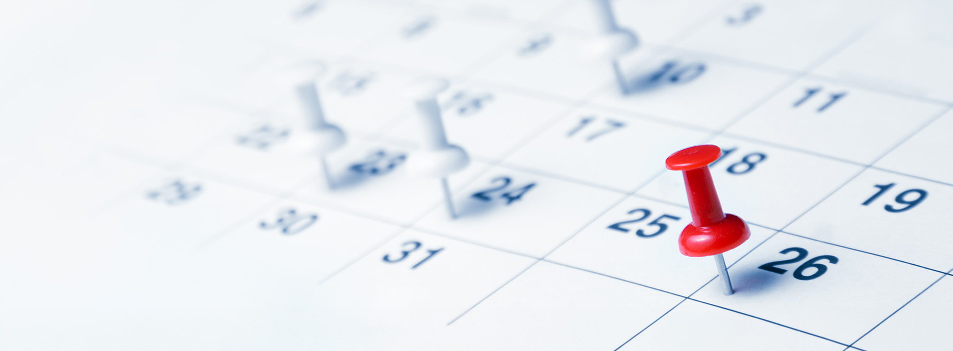 The image shows a calendar with a red thumbtack placed on the 6th day of the month, indicating an upcoming event or appointment.